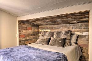 a bedroom with a bed with a wooden wall at Dog-Friendly Cabin Near Tonto National Forest! in Payson