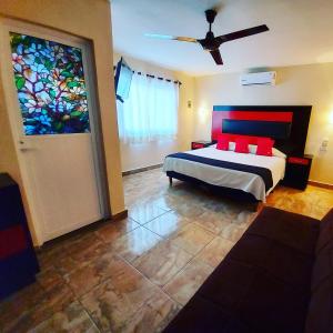 1 dormitorio con cama y vidriera en Hotel Jardín Cancún en Cancún