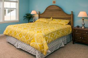 a bedroom with a large bed with a yellow comforter at Sunset Island - 3 Canal Side Mews in Ocean City +29 photos