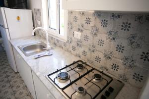 a kitchen with a stove top oven next to a sink at Stromboli sea view apartment in Tropea