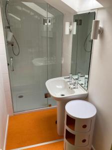 a bathroom with a sink and a glass shower at Yew Tree Cottage in Bath