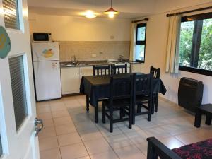 a kitchen and dining room with a table and a refrigerator at Los Paraisos in Villa Gesell