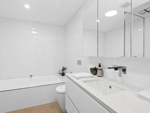 a white bathroom with a sink and a toilet at Oceania 3 in Lorne +21 photos