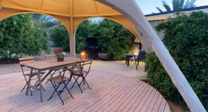 a patio with a table and chairs and a grill at Unique Farm Cottage in Al-ʿUla