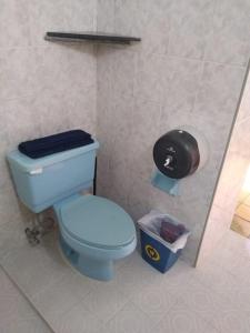 uma casa de banho com um WC azul e uma lata de lixo em Hostal don Felipe em Guadalajara