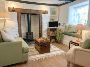 a living room with two couches and a fireplace at Clover Cottage in Plymouth