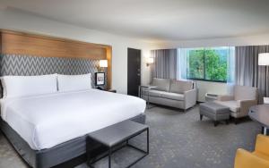a hotel room with a large bed and a chair at Holiday Inn Asheville East-Blue Ridge Pkwy by IHG in Asheville