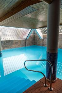 a swimming pool with a chair in the middle at Hotel Ría de Suances in Suances