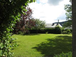 einen Garten mit grünem Rasen mit Bäumen und einem Haus in der Unterkunft Lavish Holiday Home in Forri res with Sauna in Lesterny