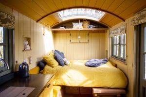 Little Plovers Shepherd Hut في شيشستر: غرفة نوم بسرير في غرفة صغيرة