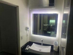 y baño con lavabo y espejo. en Motel Pedregal en Guadalajara