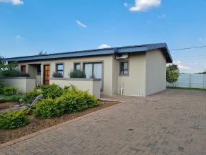 a house with a driveway in front of it at Village Kulture - Guest House in Rustenburg