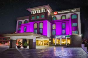 パチューカ・デ・ソトにあるBest Western Plus Santa Cecilia Pachucaの紫色の照明が目の前にある建物