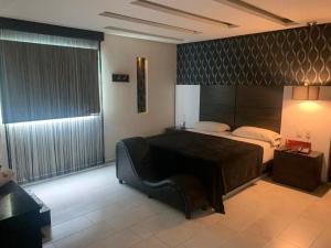 グアダラハラにあるMotel Casablancaの大きなベッドと大きな窓のある寝室