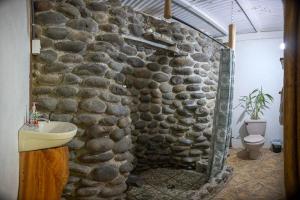 a stone bathroom with a sink and a stone wall at Casa Méndez B&B in Tetsalia