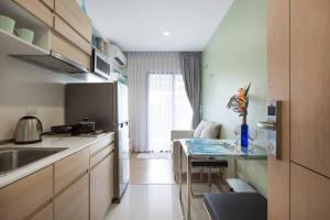 a kitchen with a sink and a table in it at Beach Style Condo Pool, Gym, 1100m To Great Beach. in Nai Yang Beach
