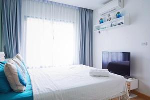 a bedroom with a bed and a tv and a window at Beach Style Condo Pool, Gym, 1100m To Great Beach. in Nai Yang Beach
