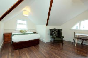 een slaapkamer met een bed, een stoel en een bureau bij Harry Clarke Mews at the Castle Hotel in Dublin