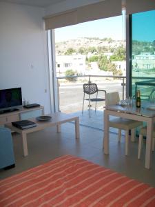 - un salon avec une table, des chaises et une télévision dans l'établissement A209 Coralli Spa, Cyprus - Med View Studio, à Protaras