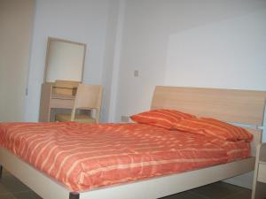 - une chambre dotée d'un lit avec des draps orange et un miroir dans l'établissement A209 Coralli Spa, Cyprus - Med View Studio, à Protaras
