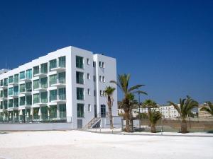 un bâtiment blanc avec des palmiers devant lui dans l'établissement A209 Coralli Spa, Cyprus - Med View Studio, à Protaras