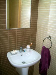 La salle de bains est pourvue d'un lavabo blanc et d'un miroir. dans l'établissement A209 Coralli Spa, Cyprus - Med View Studio, à Protaras