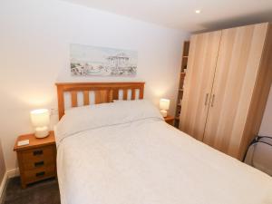 a bedroom with a white bed and two lamps at Sea Scape in Caernarfon