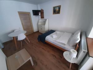 Un pequeño dormitorio con una cama y una mesa. en Studio Gmitrovic, en Rtanj