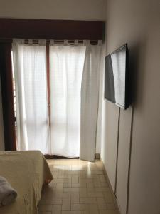 1 dormitorio con 1 cama y TV frente a una ventana en Departamento Belgrano 4 en Salta