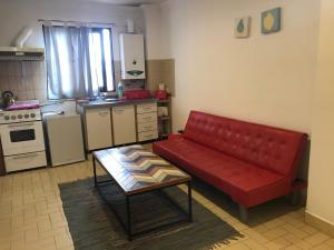 sala de estar con sofá rojo en la cocina en Departamento Belgrano 4 en Salta