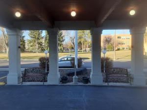 a porch with two benches and a car in a parking lot at Days Inn by Wyndham Pocatello University Area in Pocatello