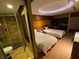 ein Hotelzimmer mit 2 Betten und einer Dusche in der Unterkunft Jinsa Lakeside View Resort in Jinsha