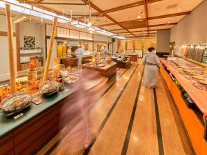 une femme qui traverse une ligne de buffet dans un restaurant dans l'établissement Yukai Resort Gero Saichoraku Bekkan, à Gero