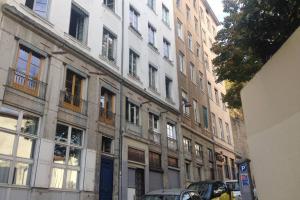 a tall building with cars parked in front of it at Studio Lyon 1er in Lyon
