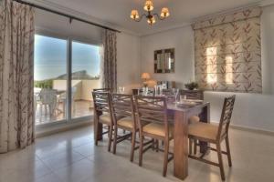 uma sala de jantar com uma mesa de madeira e cadeiras em La Manga Club Resort - Monte Verde 352 em Atamaría