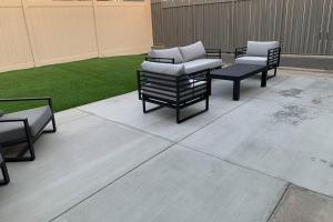 a patio with four chairs and a lawn at City Center Villa - Pool, Patio & Close To Beach! in Huntington Beach
