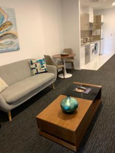 uma sala de estar com um sofá e uma mesa de centro em The Palms Apartments em Adelaide