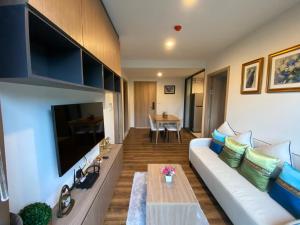 a living room with a couch and a tv at La HABANA Condo 135/500 in Hua Hin