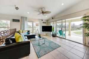 a living room with a couch and a tv at Oasis by the Sea Beach Front Community - Luxurious Pool Spa Home with Waterfall - Sleeps 10 - Come in Palm Coast