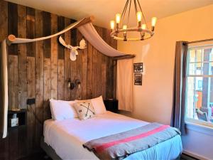 1 dormitorio con cama y lámpara de araña en Mrs. Anderson's Lodging en Leavenworth