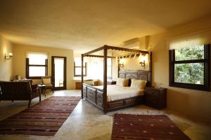 1 dormitorio con cama con dosel y sala de estar. en Exclusive Boutique Hotel, en Kızılcakaya