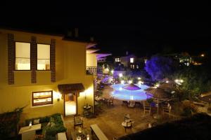 an outdoor patio with tables and umbrellas at night at Exclusive Boutique Hotel in Kızılcakaya