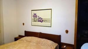 1 dormitorio con 1 cama y una foto en la pared en Sea Cinque Terre. Calm, cool, freedom good for children and pet. WiFi Parking, en Carrodano Inferiore