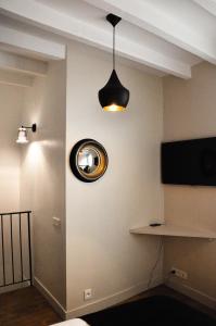 a room with a television and a light on the wall at Charming duplex in Montmartre in Paris