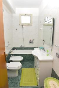 a bathroom with two sinks and a toilet and a tub at APARTMENT IN VILLA (NEAR THE SEA) in Porto Palo