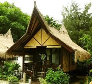 een klein huis met een rieten dak bij Ana Warung & Bungalows in Gili Meno