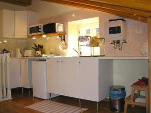 uma cozinha com armários brancos e uma bancada em Welcome to Casa Terracotta a cosy self-catering holiday home. em Masanti