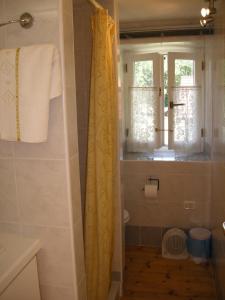 a bathroom with a shower with a yellow shower curtain at Welcome to Casa Terracotta a cosy self-catering holiday home. in Masanti