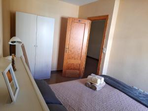 una camera con letto e porta in legno di 2 bedrooms appartement with balcony and wifi at Las Gabias a Las Gabias