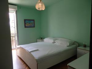 Un dormitorio con una cama blanca con una ventana. en Holiday apartment with a balcony and sea view, just 300 metres from the beach, en Bol